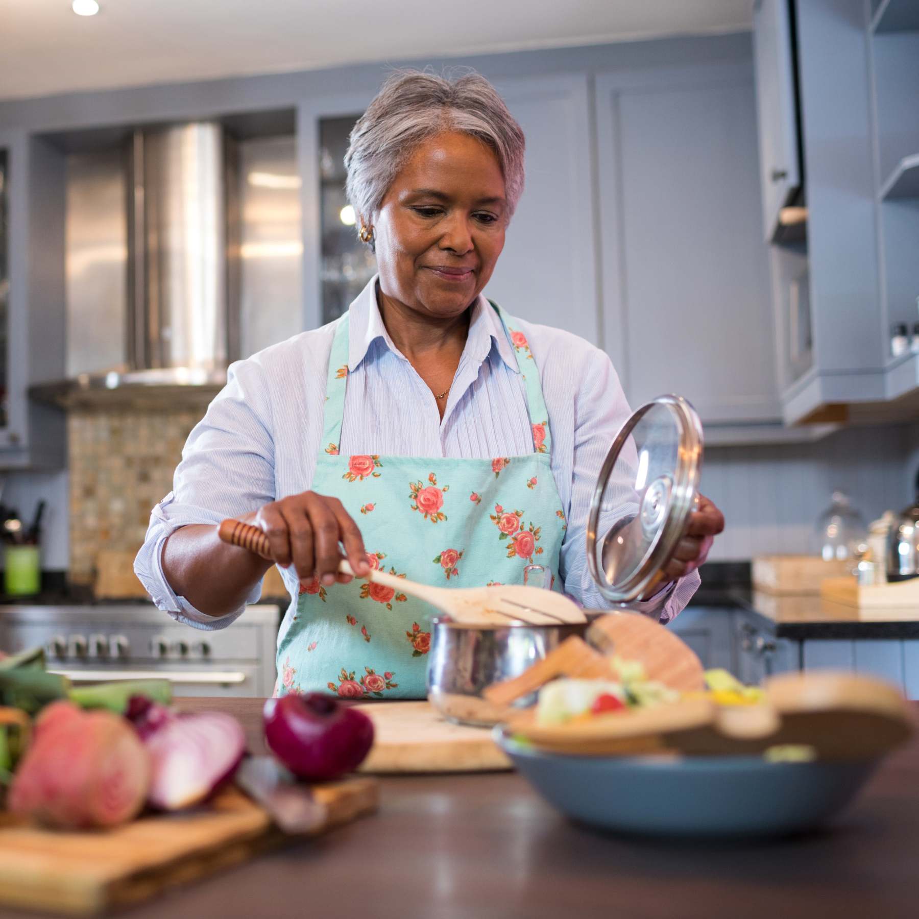 Cuisinière expérimentée âgée prépare des plats dans la cuisine.