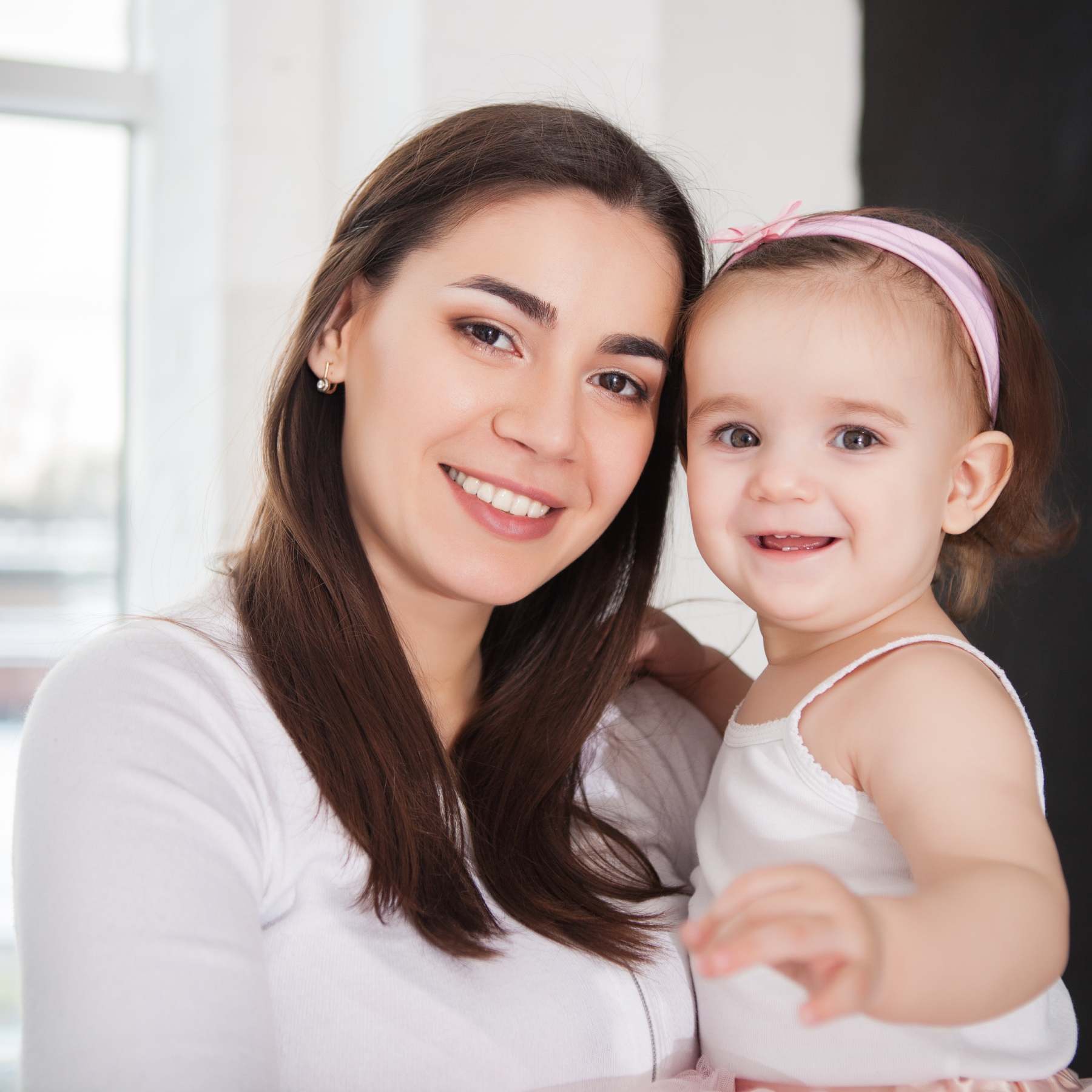 Une nounou et une petite fille échangent un sourire complice.